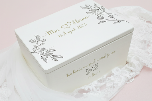 Personalisierte Erinnerungsbox für Hochzeit in Weiss mit goldigen Namen Mia und Florian und grünen Blumen auf weissem Hintergrund